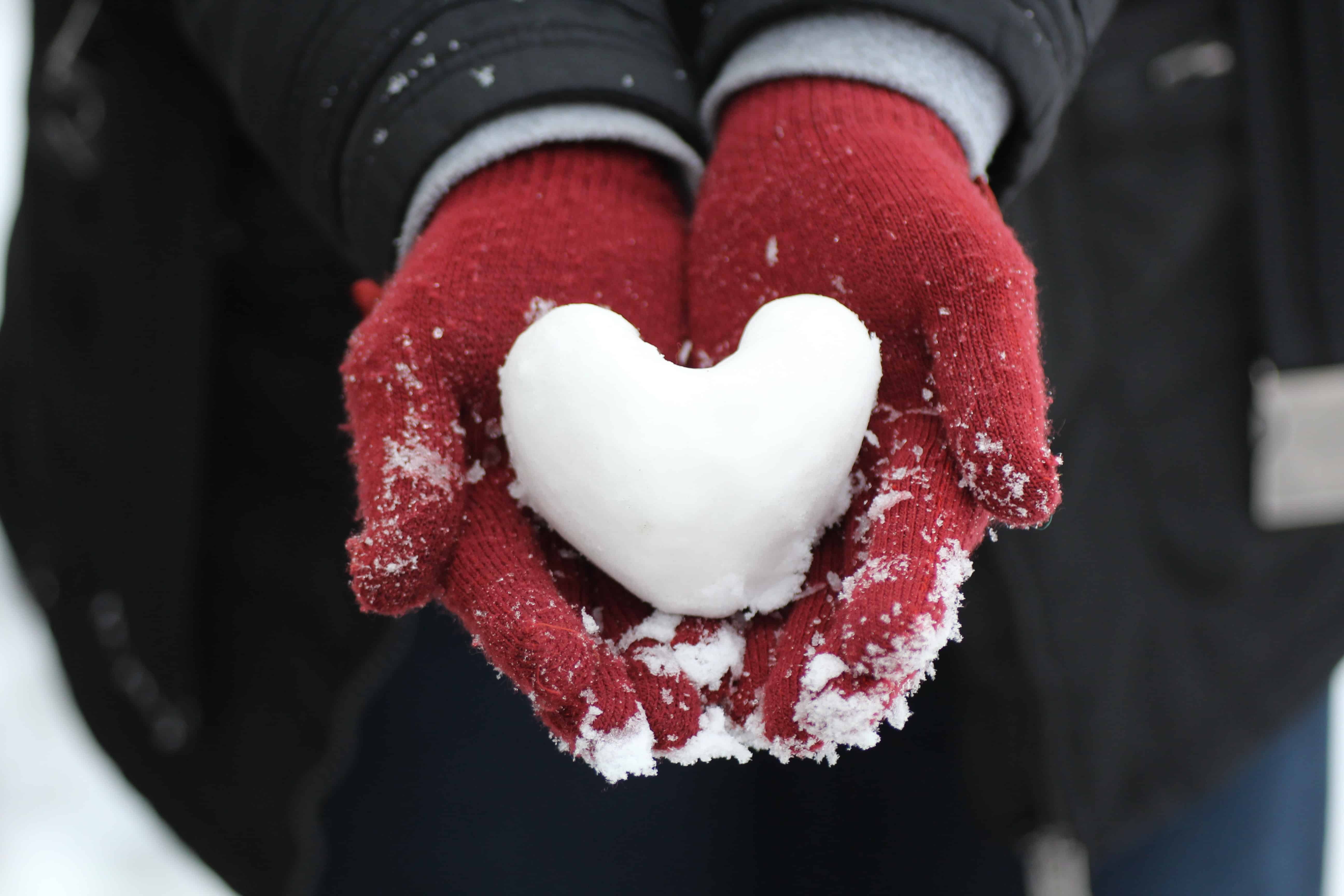 Snow heart in gloved hands